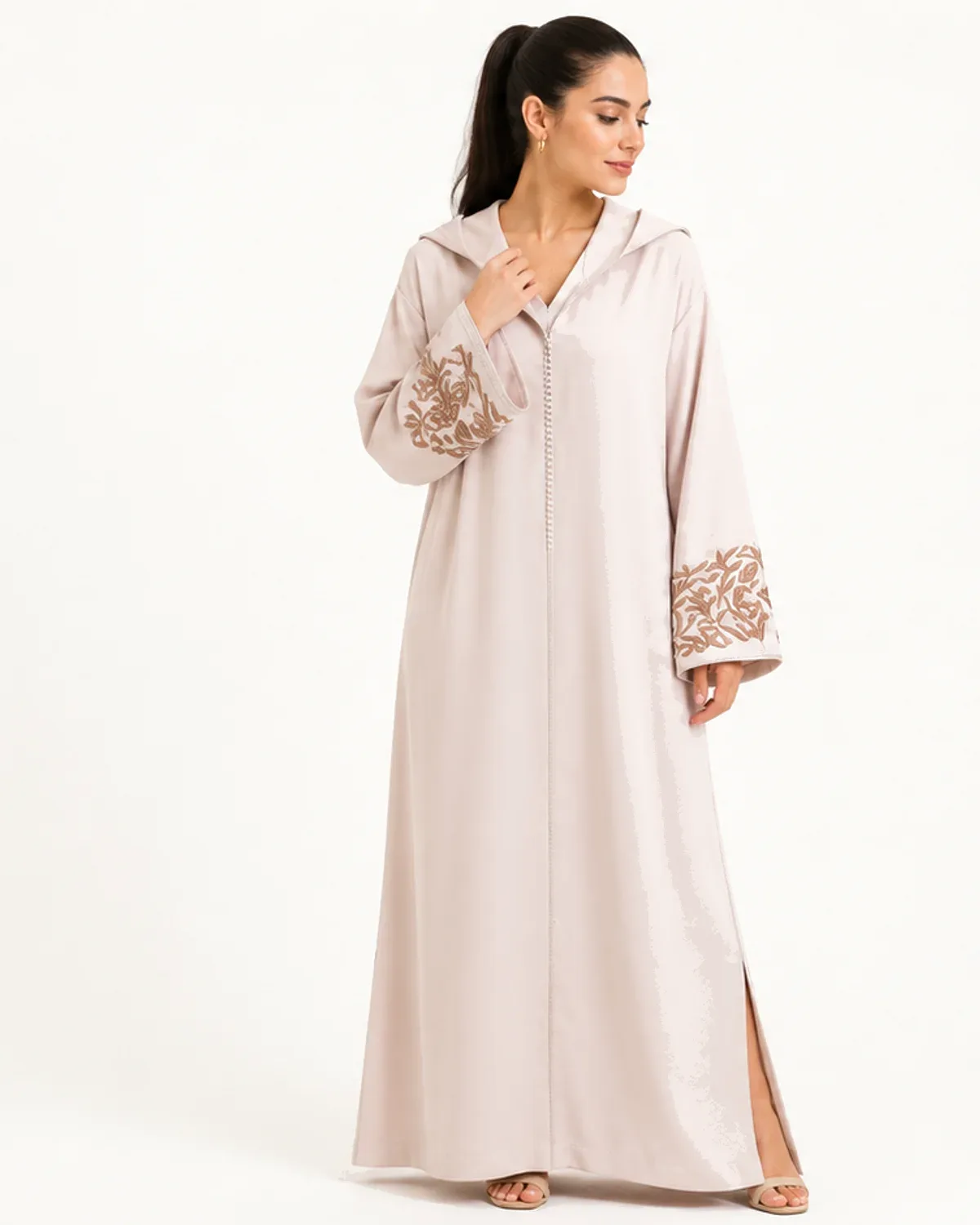 Ivory hooded Moroccan jellaba with gold cuff embroidery and rhinestone aakad buttons, front view on model